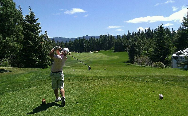A golfer mid-swing on the tee